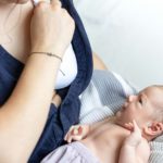 A young mother holds a newborn son in her arms, breastfeeding, lactation.