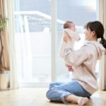 Asian mom holding a baby in the living room