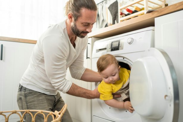 Caucasian loving parents play with baby toddler in kitchen on floor.