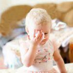 Disease, seasonal virus in a child. Allergy to dust in babies. A girl with the flu wipes her nose