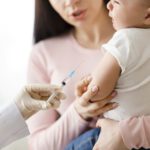 Doctor giving intramuscular injection to little baby
