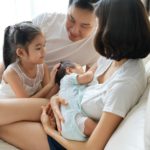 Happy family concept. Breast feeding newborn baby at home.