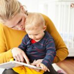 Mother and baby boy reading together